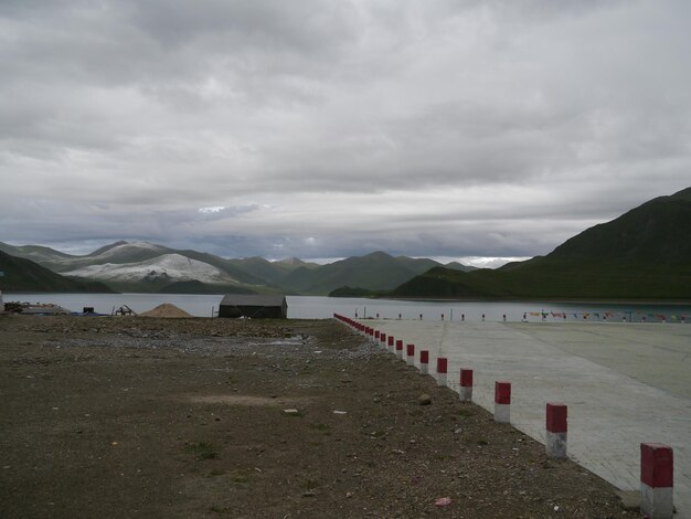 Scenic view of lake and mountains against cloudy sky