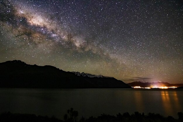 Scenic view of lake and mountains against sky at night