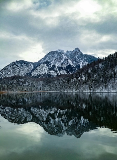 Foto la vista panoramica del lago e delle montagne innevate contro il cielo