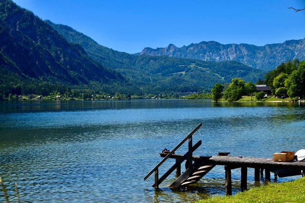 Scenic view of lake with landing stage and mountains against clear sky