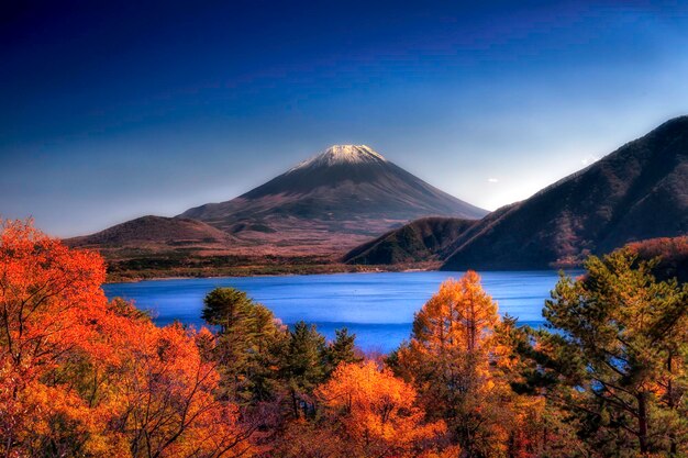 Photo scenic view of lake with mountain in background