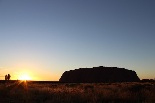 Scenic view of land against clear sky during sunset