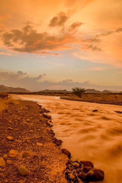 Scenic view of land against sky during sunset