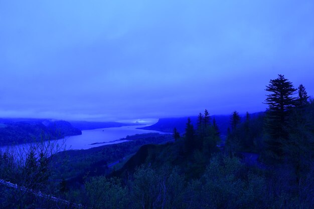 Scenic view of landscape against blue sky at dusk