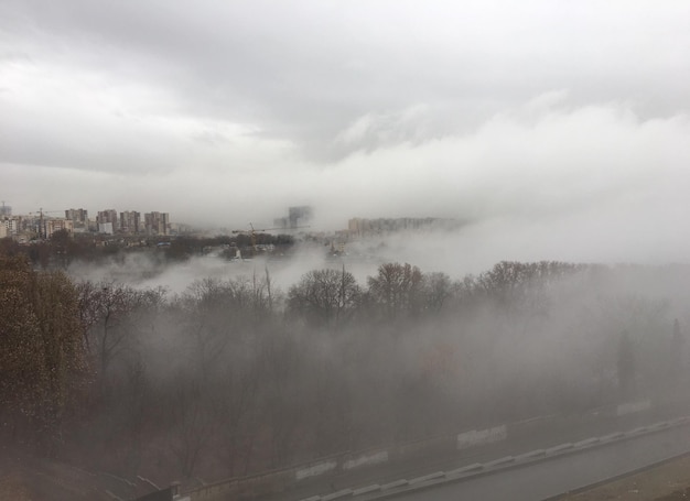 Photo scenic view of landscape against sky during foggy weather