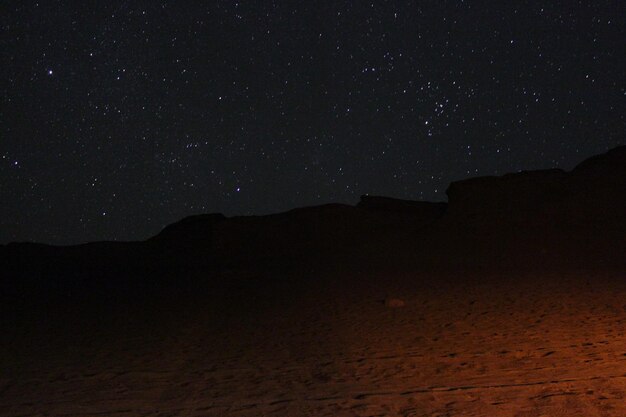 Photo scenic view of landscape against star field at night