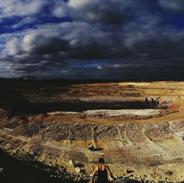 Photo scenic view of landscape against stormy clouds