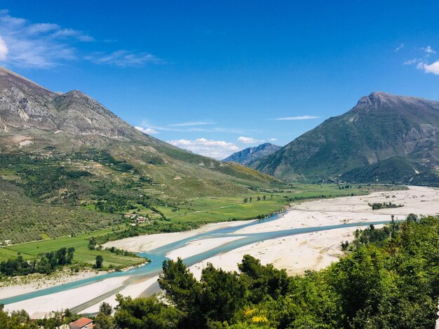 Scenic view of landscape and mountains against blue sky