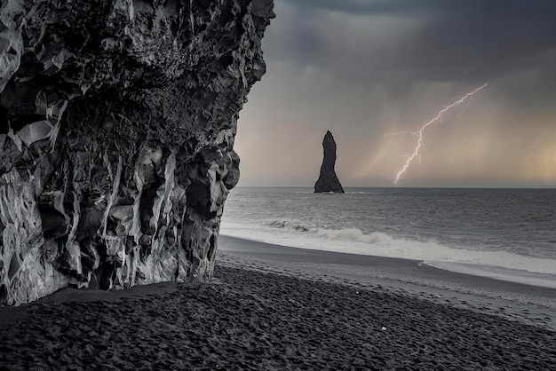 Vista panoramica del fulmine sulla spiaggia nera di reynisfjara durante la notte tempestosa