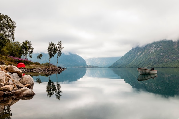 Foto vista panoramica della barca solitaria sul lago idilliaco