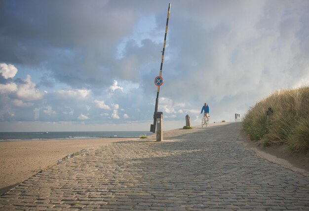 Scenic view of man cycling and  sea against sky