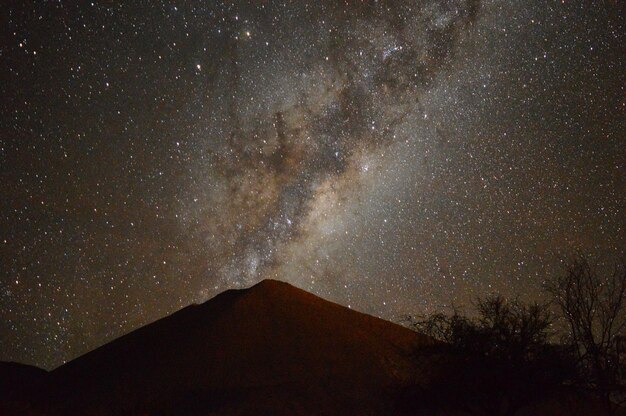 Photo scenic view of mountain against star field at night