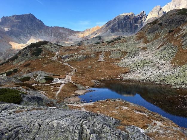 Photo scenic view of mountain by pond against sky