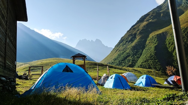 Scenic view of mountains against blue sky with tents