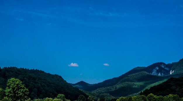 Scenic view of mountains against blue sky