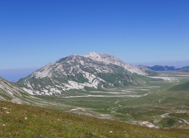 Scenic view of mountains against clear blue sky