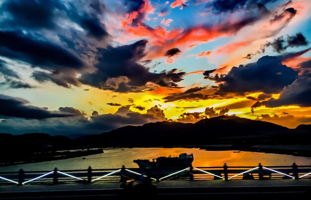 Scenic view of mountains against cloudy sky at sunset