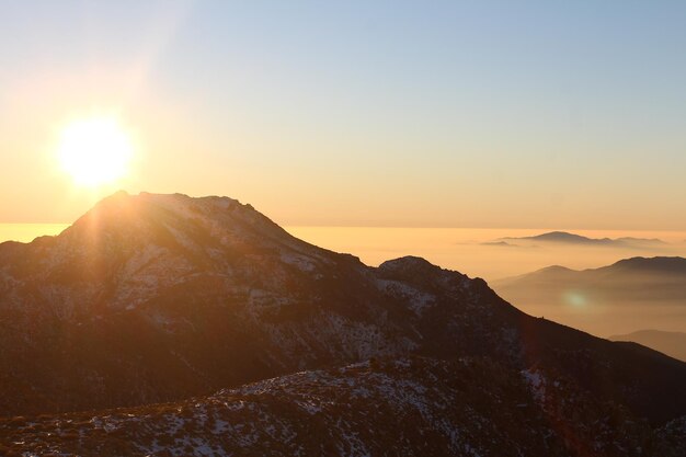 Photo scenic view of mountains against sky during sunset