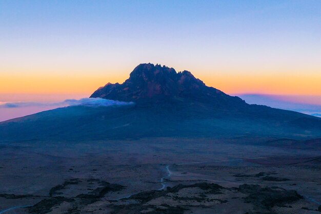 Photo scenic view of mountains against sky during sunset