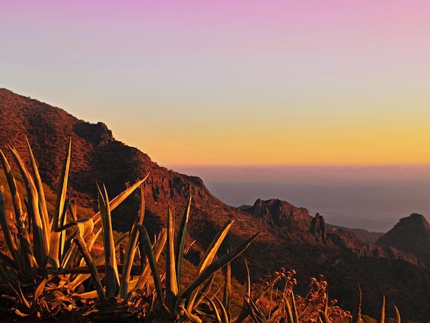 Photo scenic view of mountains against sky during sunset