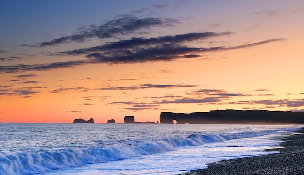 Scenic view of mountains by sea against sky during sunset