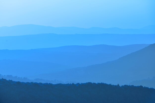 Photo scenic view of mountains in foggy weather