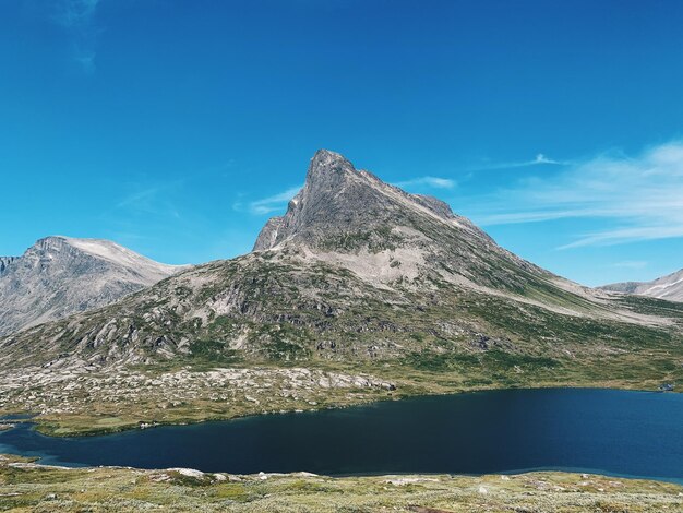Scenic view of mountains and nordic lake against blue sky in wilderness with copyspace