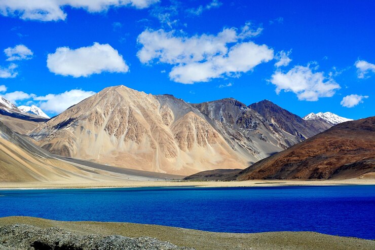फोटो scenic view of mountains and river against cloudy sky