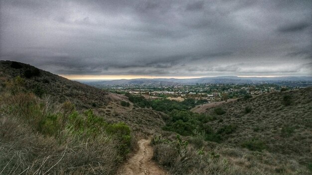 Photo scenic view of mountains and village against cloudy sky