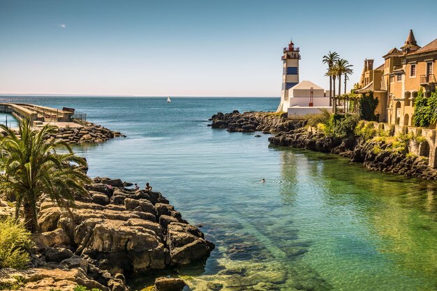 Scenic view of the mouth of a river with a lighthouse against the sea and clear sky