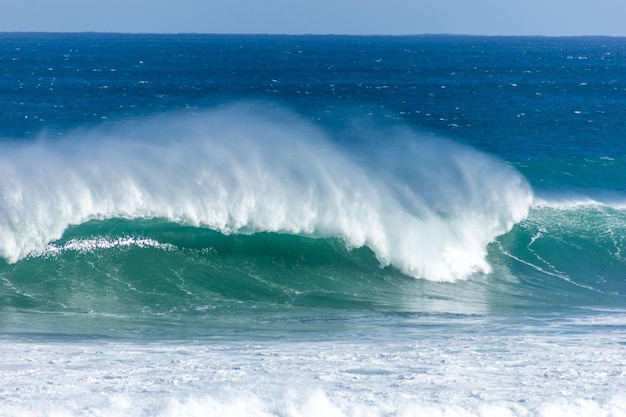 Scenic view of ocean waves under a blue sky on a sunny day