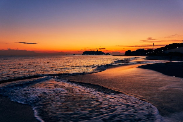 写真 夕暮れの空に照らされたビーチの景色