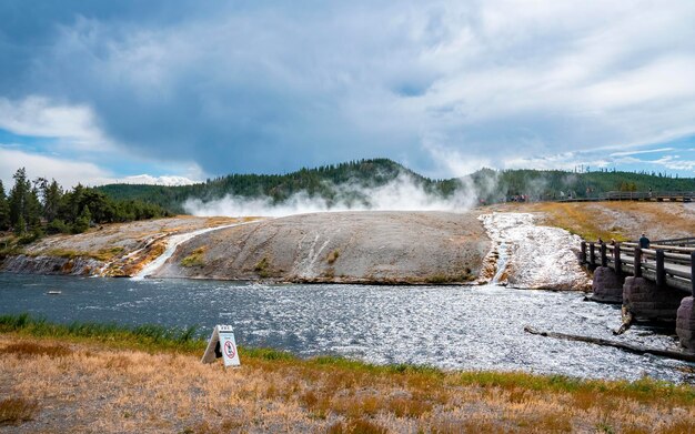 Фото Сценический вид извержения рекой firehole в гейзере midway в парке йеллоустоун