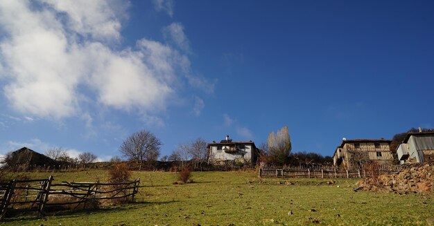 Фото Пейзажный вид на поле с домами на фоне неба