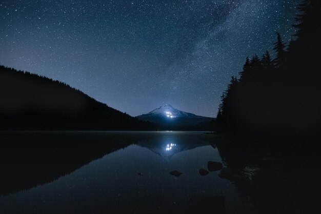 写真 夜に湖に反射する照らされた山の風景