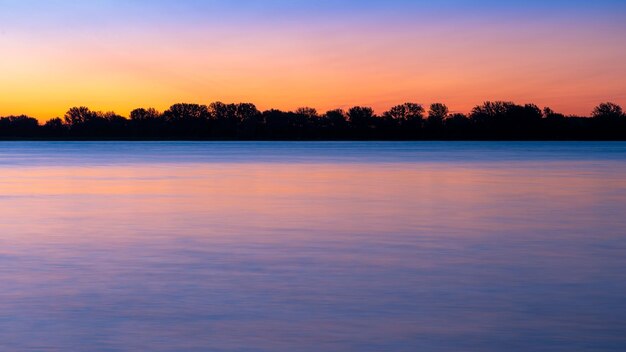 写真 オレンジ色の空を背景に湖の景色