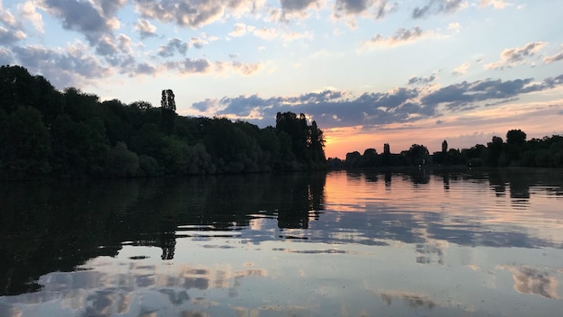 写真 夕暮れ の 空 に 照らさ れ て いる 湖 の 景色