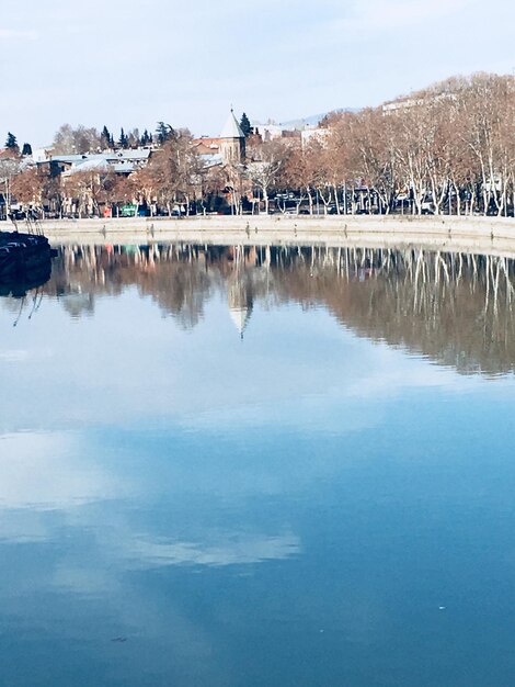 写真 空に照らされた建物による湖の景色