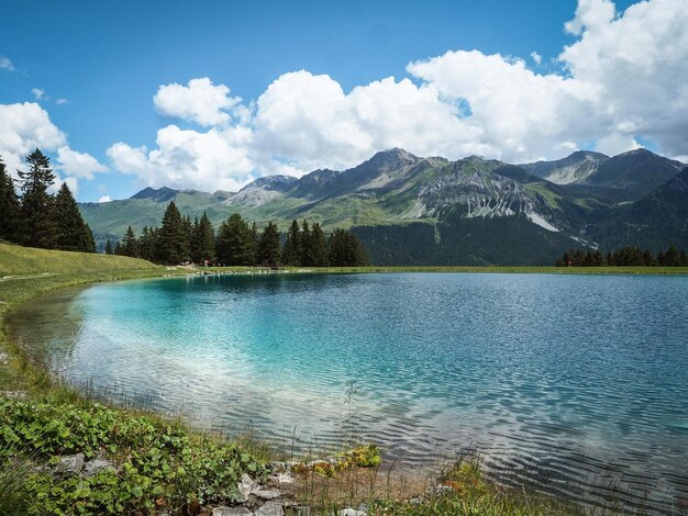 写真 空に照らされた山々から湖の景色