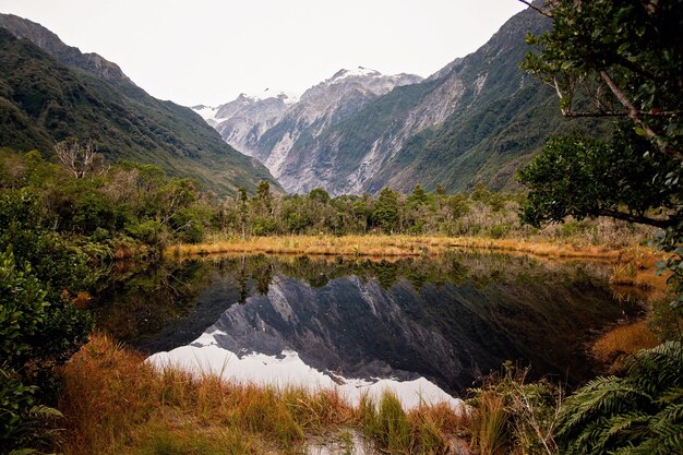 写真 空の背後にある山から湖の景色