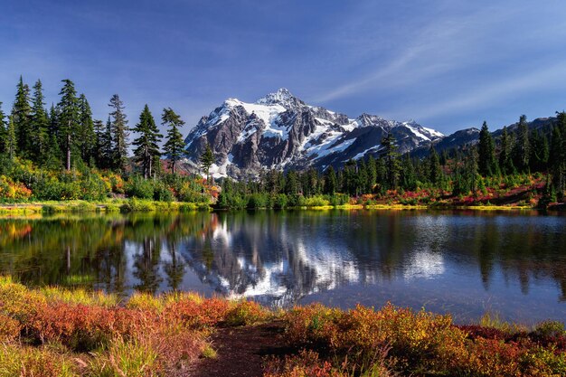 Фото Красивый вид на озеро с заснеженными горами на фоне неба