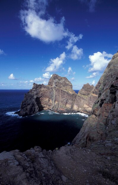 写真 青い空を背景に海から見える岩の山の景色