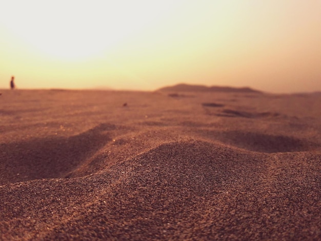 Фото Пейзажный вид на песчаные дюны на фоне неба при заходе солнца