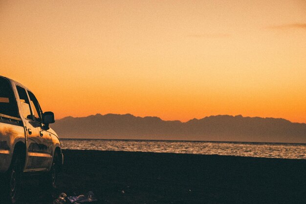 写真 夕暮れの晴れた空に照らされた海の景色