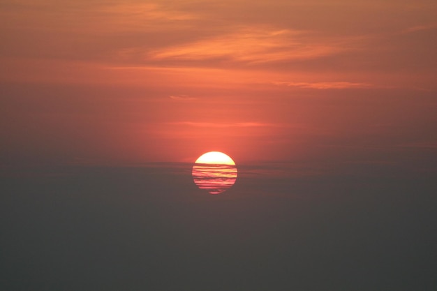 写真 オレンジ色の空を背景に海の景色