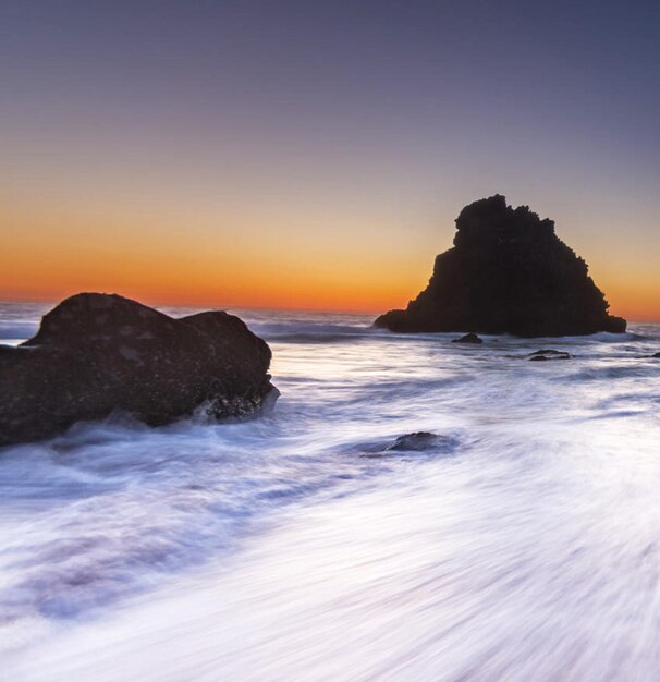 写真 夕暮れの空に照らされた海の景色