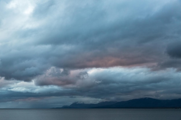 写真 夕暮れの嵐の雲に照らされた海の景色