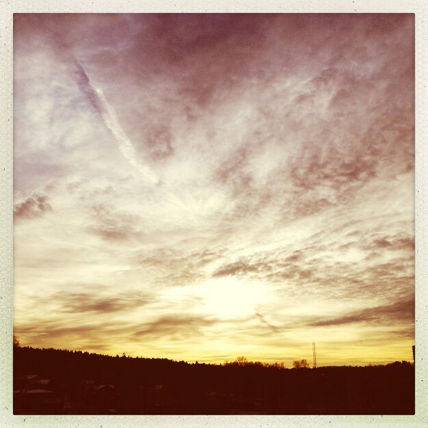 Фото Сценический вид силуэтного поля на фоне неба на закате
