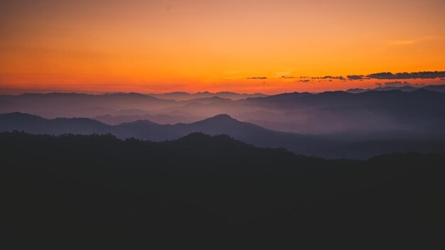 사진 오렌지색 하늘 을 배경 으로 한 산 의 실루 의 풍경