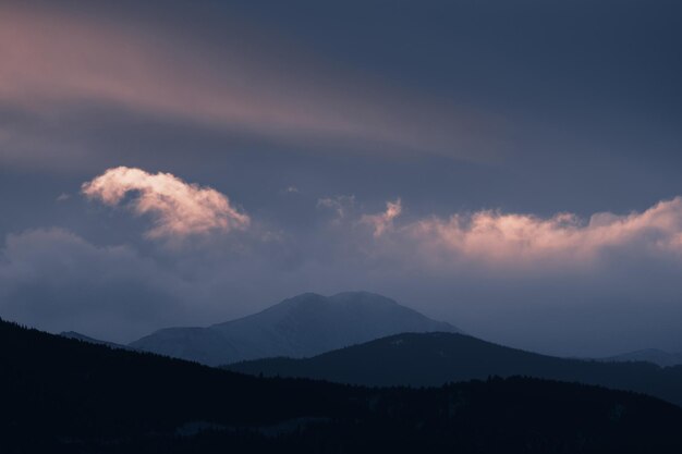 写真 夕暮れ の 空 に 照らさ れ て いる 山 の シルエット の 景色